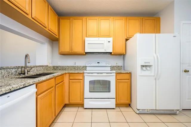 a kitchen with stainless steel appliances granite countertop a refrigerator sink and stove