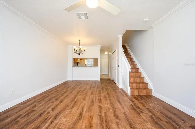 a view of a hallway with wooden floor and staircase