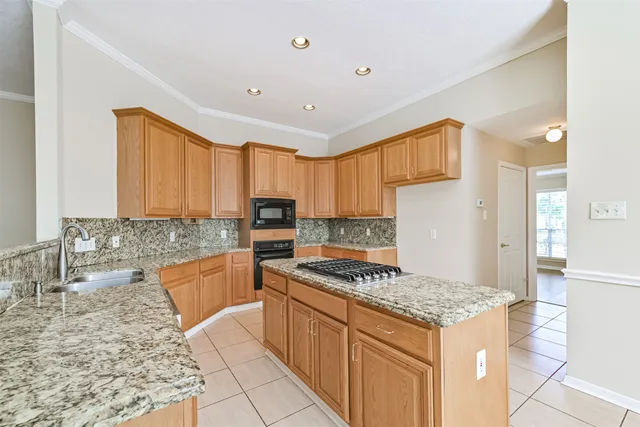 a kitchen with granite countertop a sink stove and refrigerator