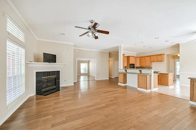 a view of kitchen with microwave a stove and a refrigerator with wooden floor