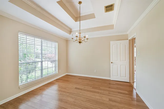 a view of a room with wooden floor and chandelier