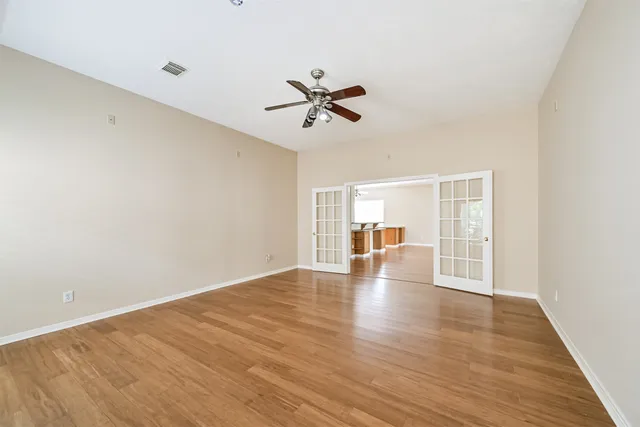 a view of an empty room with window and wooden floor