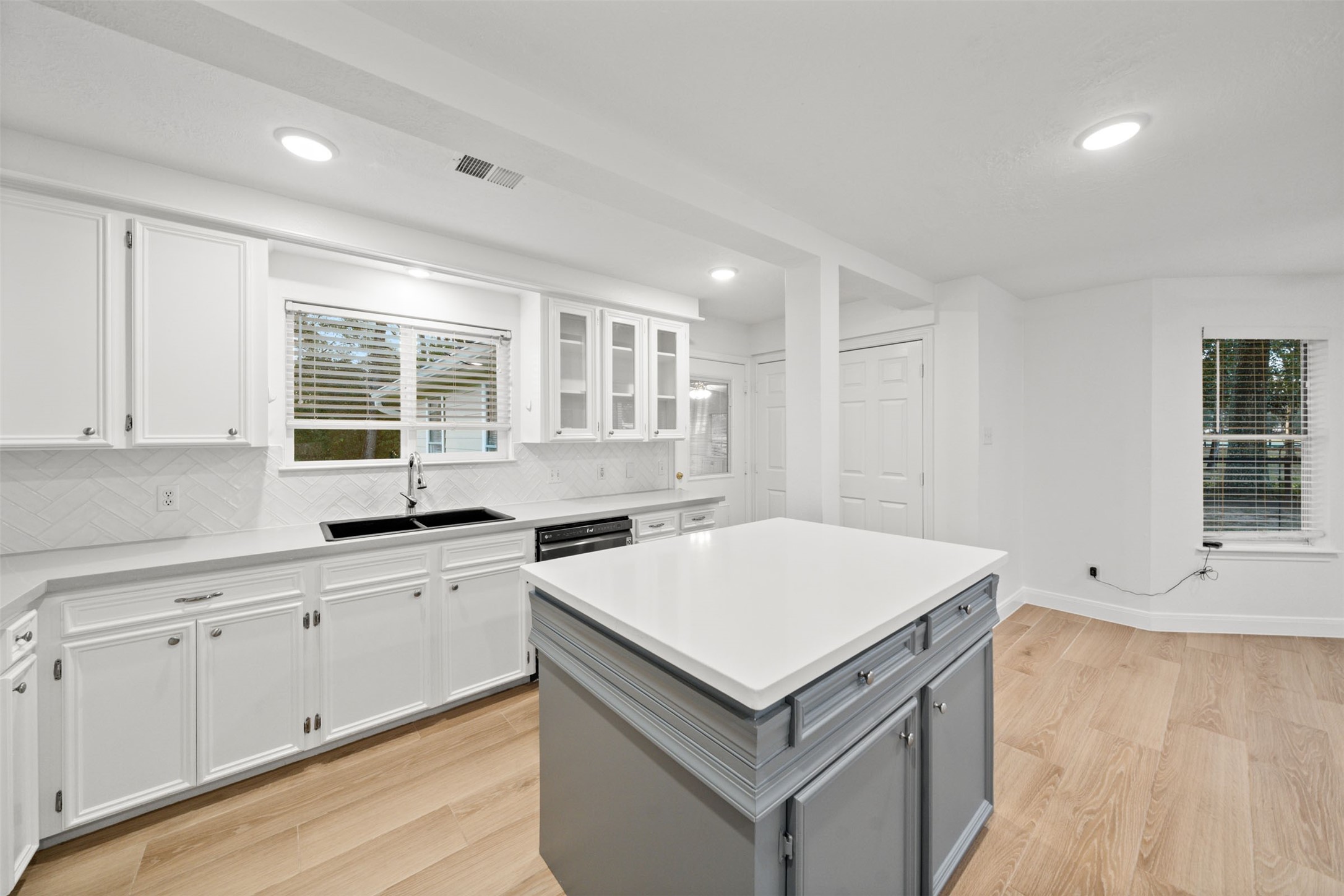 22323 Roberts Cemetery Road Hockley, TX 77447 - Photo 13 of 50 a kitchen with granite countertop a sink and white cabinets with wooden floor
