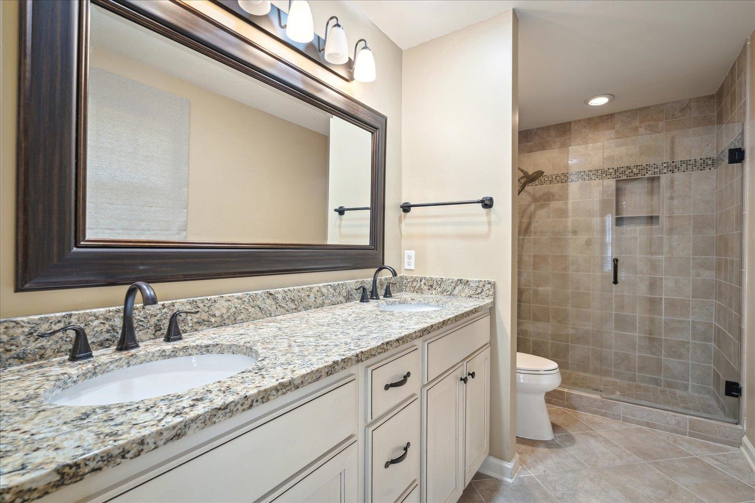 5680 Herald Square Memphis, TN 38120 - Photo 28 of 39 a bathroom with a granite countertop sink a toilet and shower