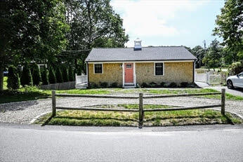 39 Nickerson Road Cotuit, MA 02635 - Photo 1 of 14 front view of a house with a bench