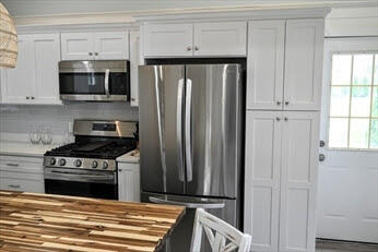 39 Nickerson Road Cotuit, MA 02635 - Photo 4 of 14 a kitchen with stainless steel appliances wooden cabinets and a stove top oven