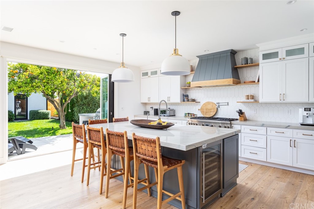 477 Magnolia Street Costa Mesa, CA 92627 - Photo 11 of 29 a kitchen with a stove a sink a kitchen island a table and chairs in it