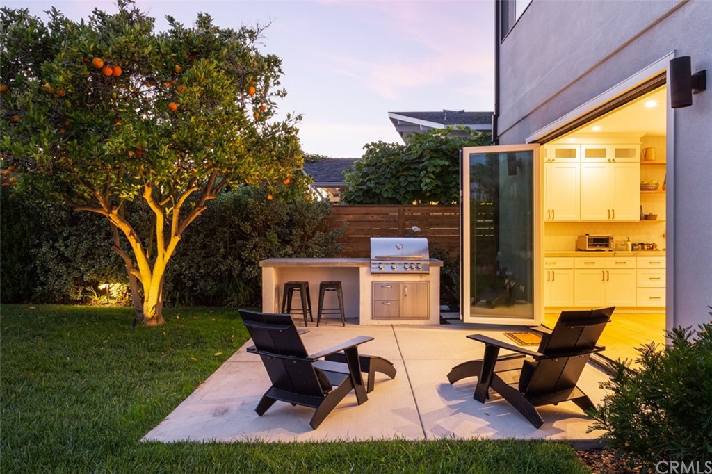477 Magnolia Street Costa Mesa, CA 92627 - Photo 12 of 29 a view of a patio with table chairs and a yard