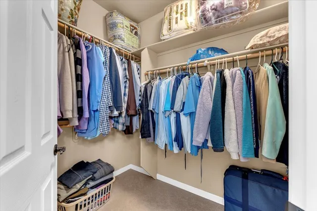 a view of walk in closet with clothes and shoes