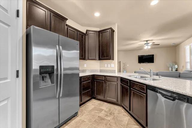 a kitchen with stainless steel appliances granite countertop a refrigerator and a sink