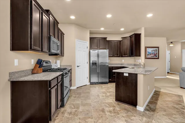 a kitchen with stainless steel appliances granite countertop a sink stove and refrigerator
