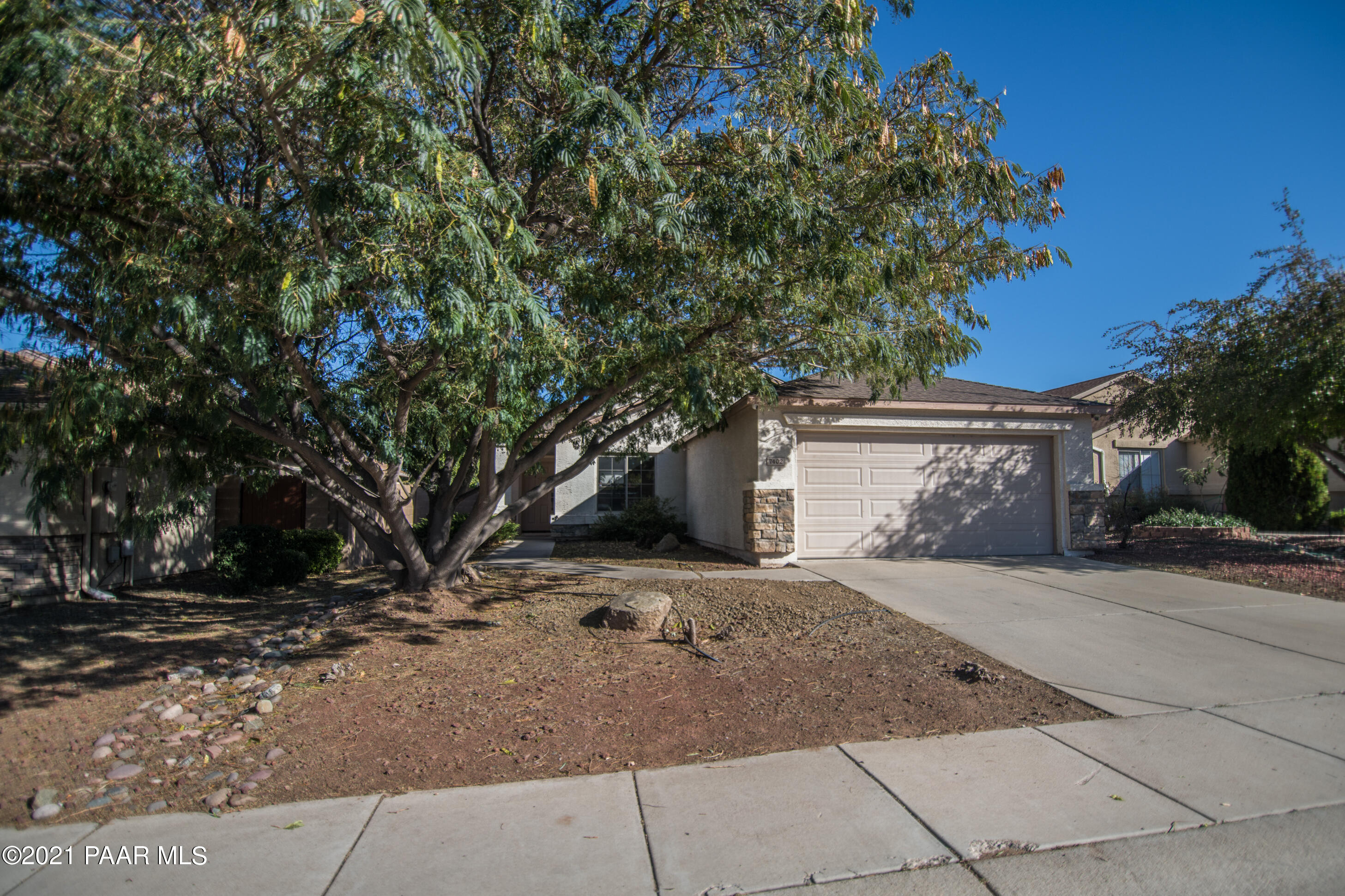 7402 East Plateau Ridge Road Prescott Valley, AZ 86315 - Photo 1 of 31 a front view of a house with a yard and garage