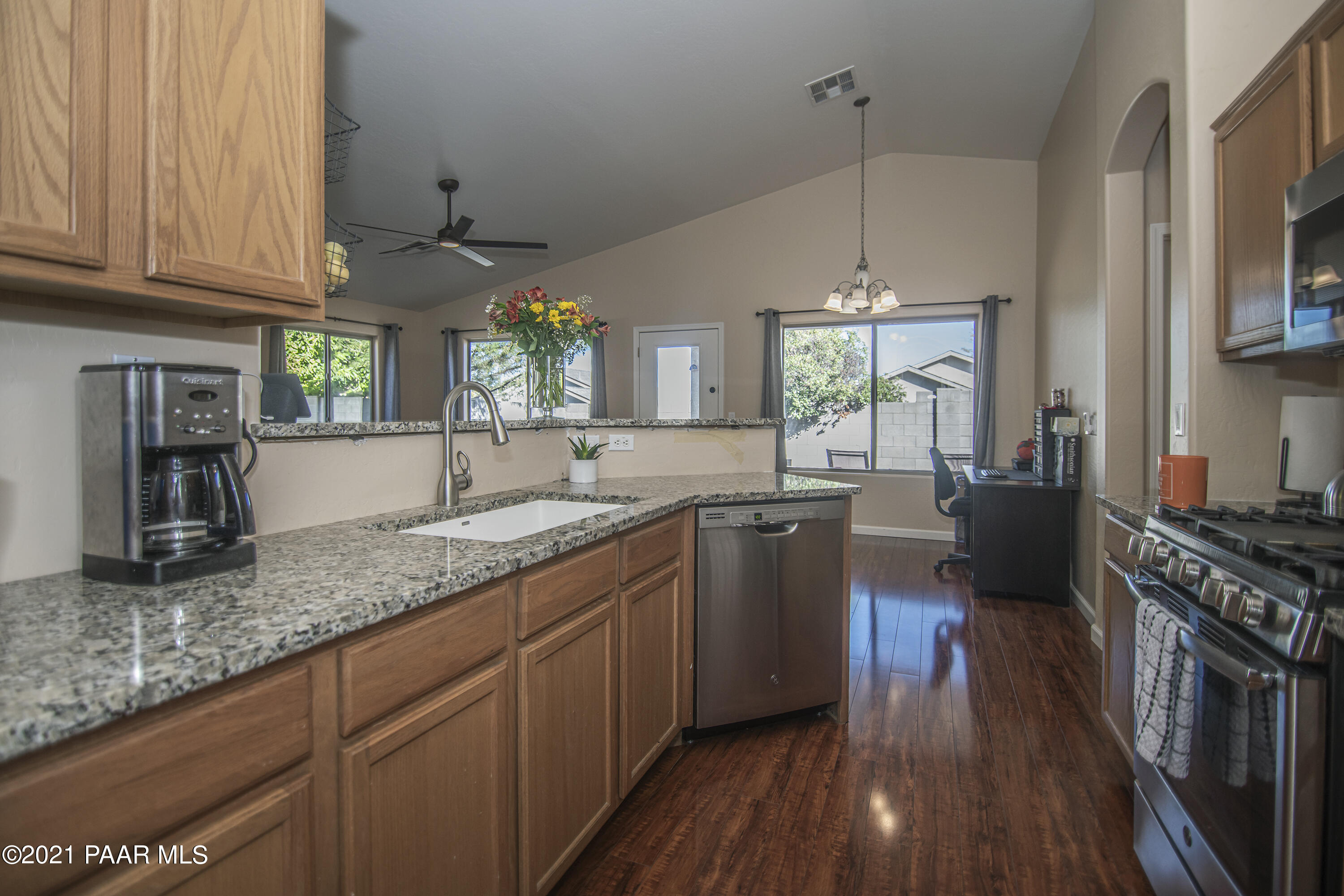 7402 East Plateau Ridge Road Prescott Valley, AZ 86315 - Photo 11 of 31 a kitchen with granite countertop a sink cabinets wooden floor and stainless steel appliances