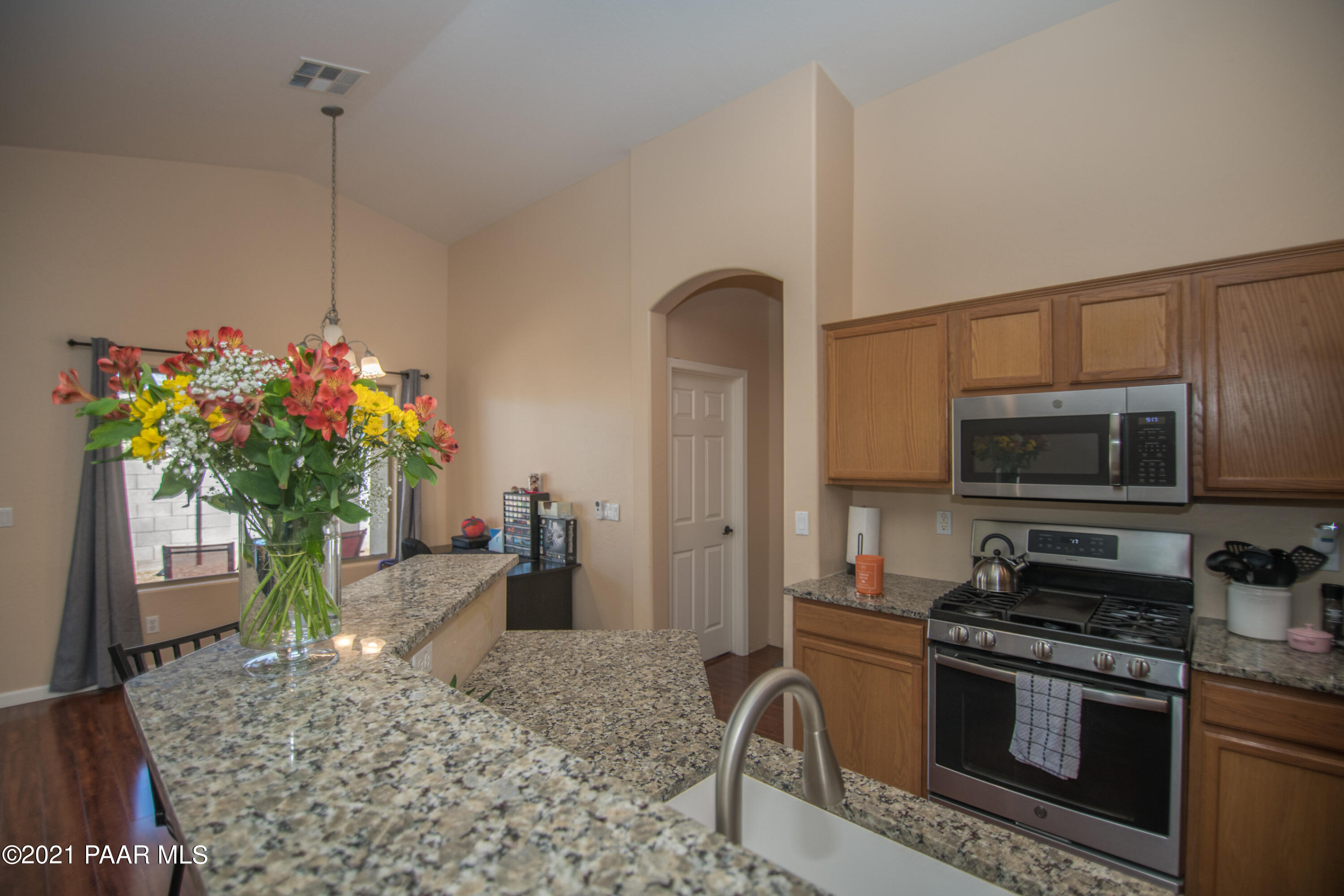 7402 East Plateau Ridge Road Prescott Valley, AZ 86315 - Photo 12 of 31 a kitchen with stainless steel appliances granite countertop a stove a sink and a microwave