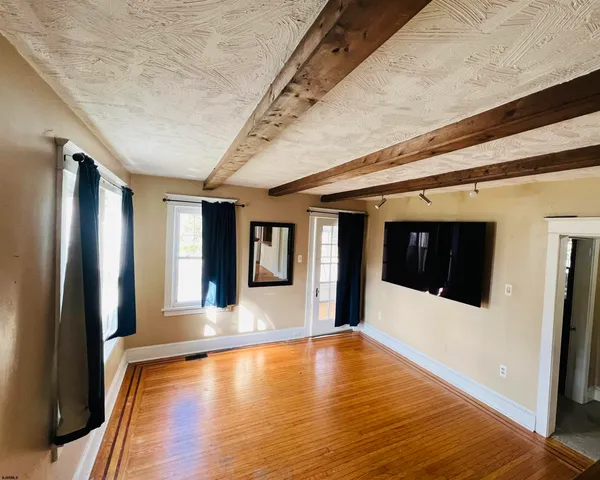 a view of a living room with stainless steel appliances wooden floor and a fireplace