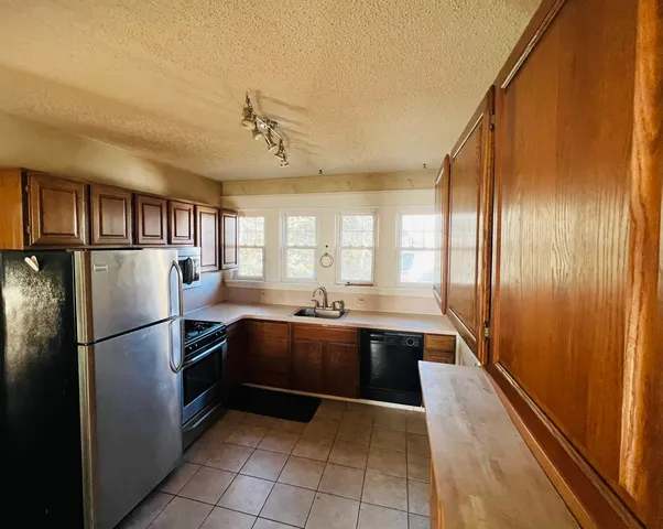 a kitchen with stainless steel appliances granite countertop a refrigerator and a sink