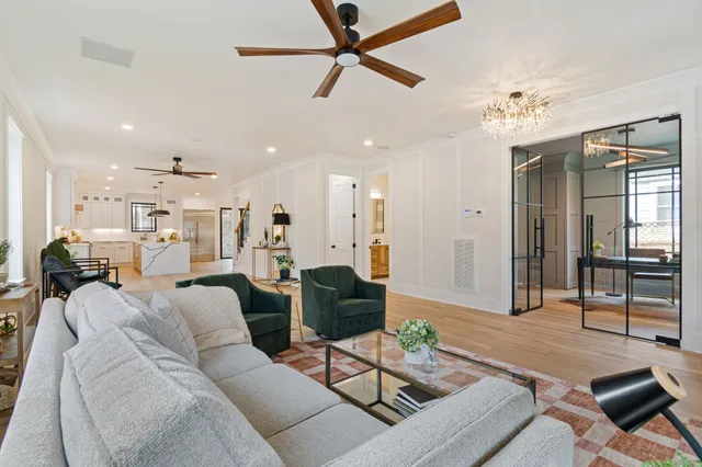 a large kitchen with stainless steel appliances kitchen island granite countertop a stove a sink a dining table and chairs with wooden floor