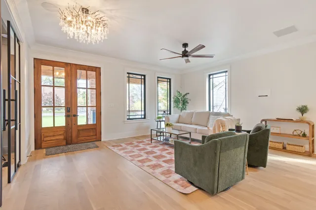 a living room with furniture kitchen view and a wooden floor