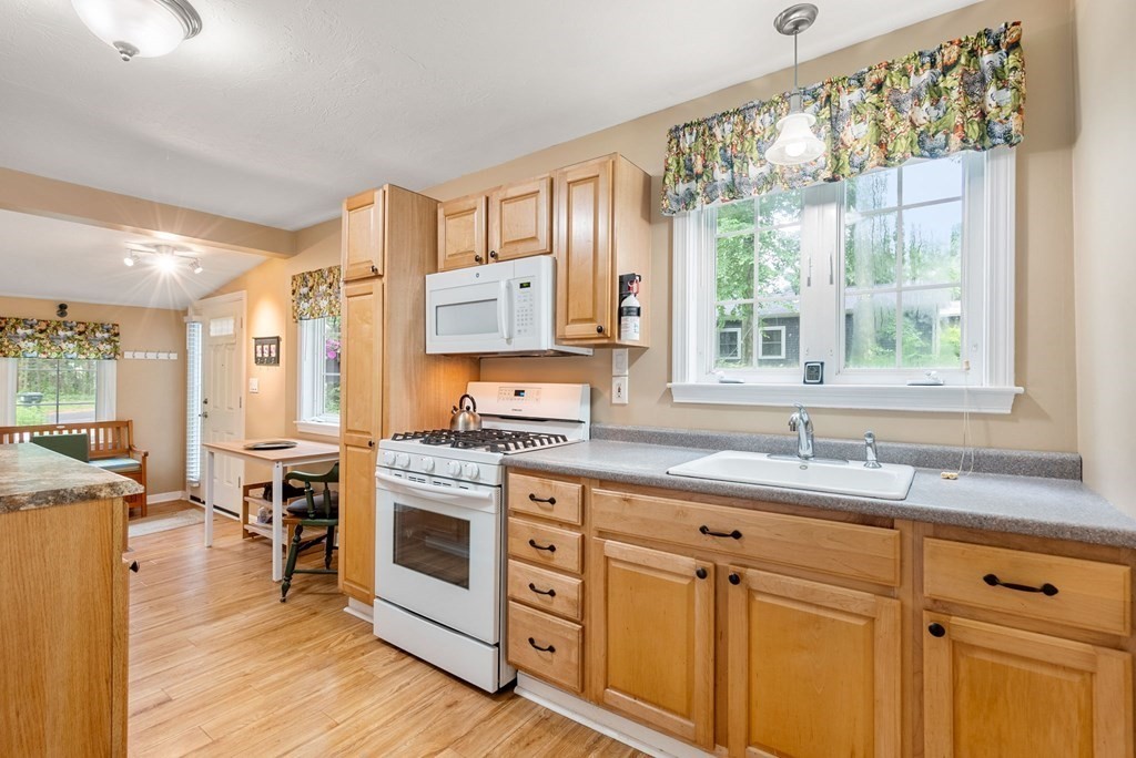 6 Craig Road Holland, MA 01521 - Photo 8 of 28 a kitchen with stainless steel appliances granite countertop a stove a sink and white cabinets with wooden floors