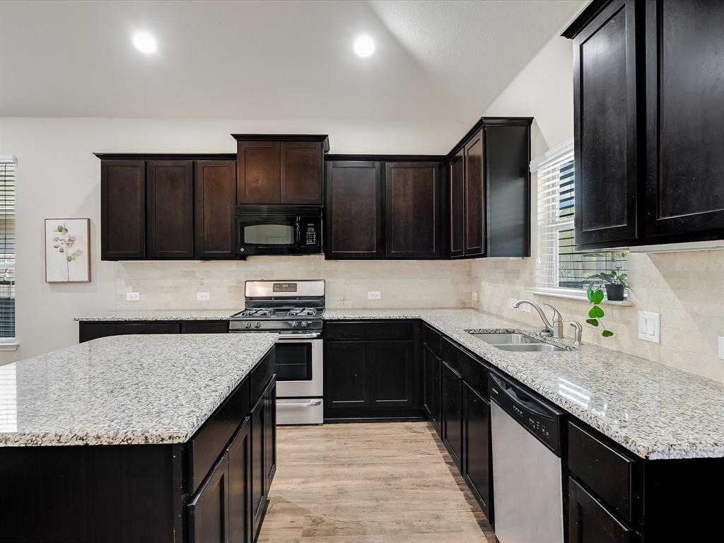 141 Serrano Street Georgetown, TX 78628 - Photo 3 of 7 Culinary delights await in this modern kitchen with extensive counter space and rich cabinetry.