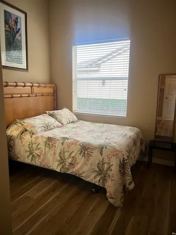 a bedroom with a bed and wooden floor