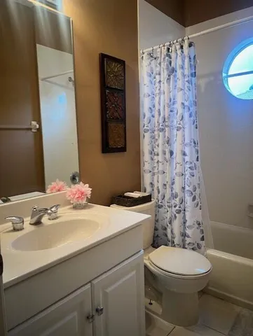 a bathroom with a sink a toilet and shower curtain