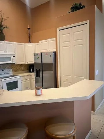 a kitchen with a sink a refrigerator and cabinets