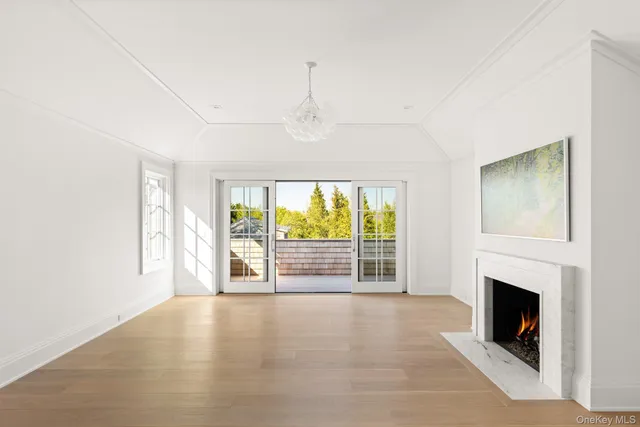 a view of empty room with floor to ceiling window and fireplace