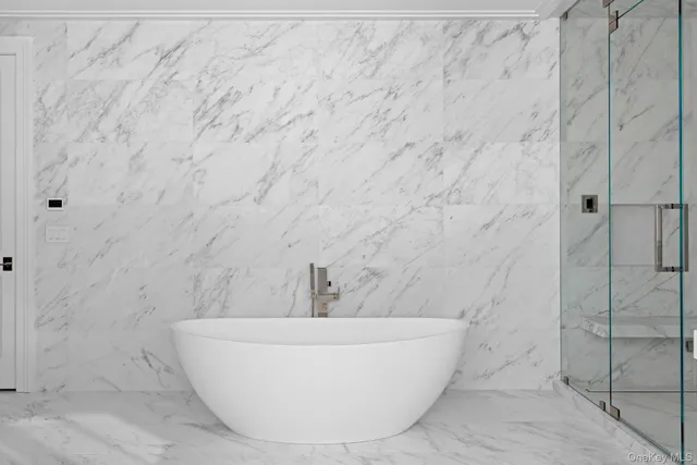 a white tub sitting next to a shower