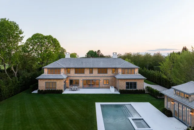 a aerial view of a house next to a big yard and large trees