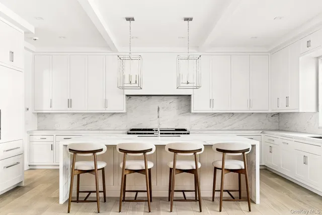 a kitchen with stainless steel appliances granite countertop a white cabinets and a stove top oven