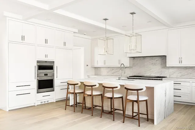 a kitchen with stainless steel appliances granite countertop a stove a refrigerator and white cabinets