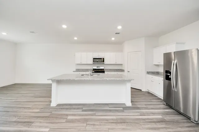 a view of kitchen refrigerator and wooden floor