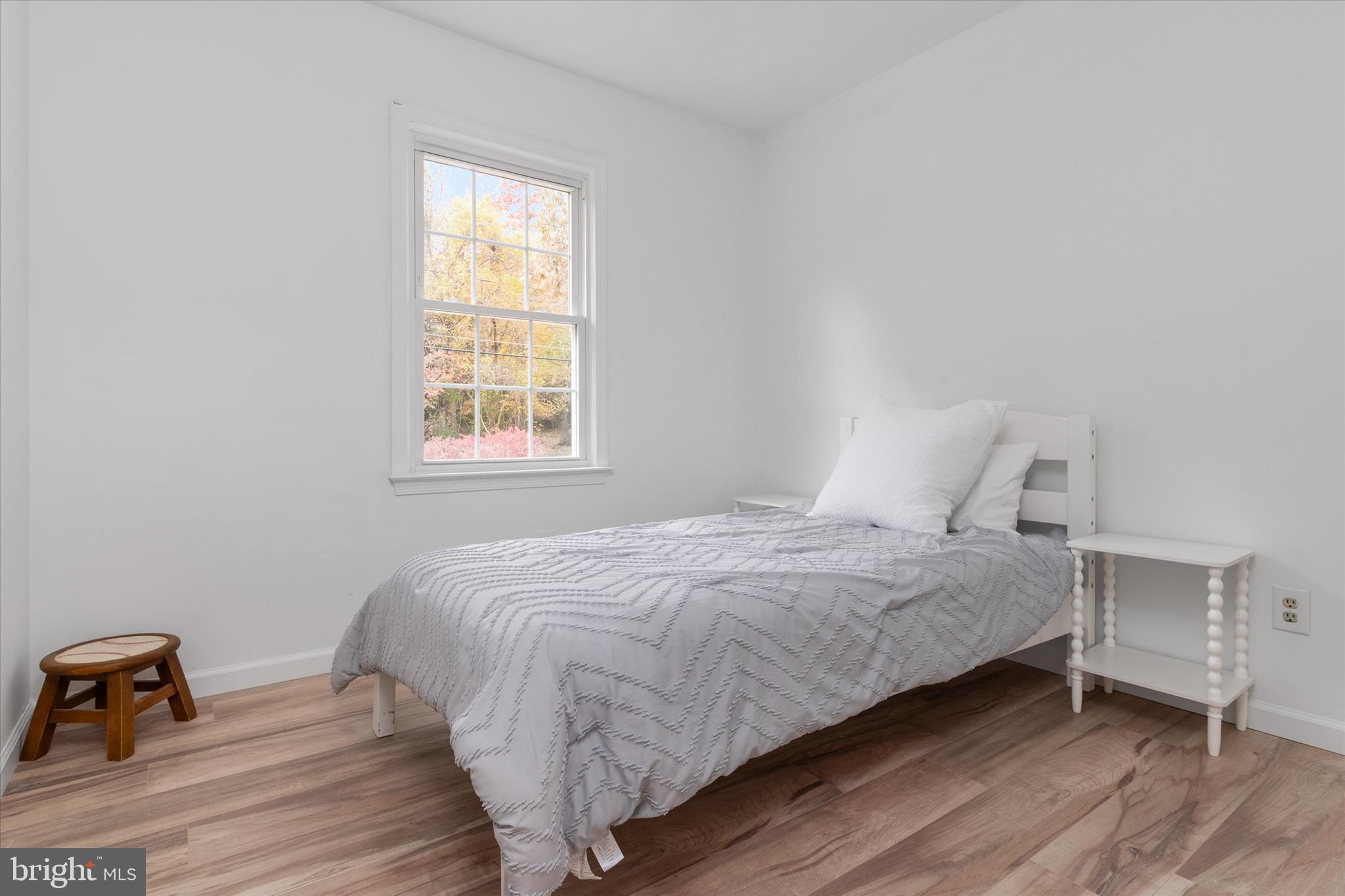 7963 Oak Road Pasadena, MD 21122 - Photo 16 of 53 a bedroom with a bed a window and a wooden floor