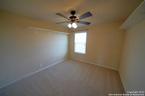 a view of a room with a ceiling fan and a window