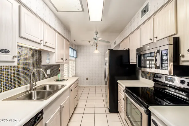 a kitchen with granite countertop a stove a sink and a refrigerator