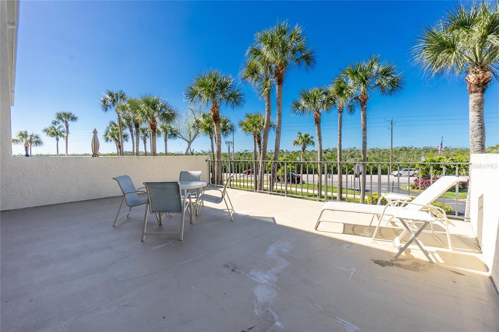1651 Beach Road, Unit 212 Englewood, FL 34223 - Photo 18 of 50 a view of a swimming pool with a lounge chair and palm trees
