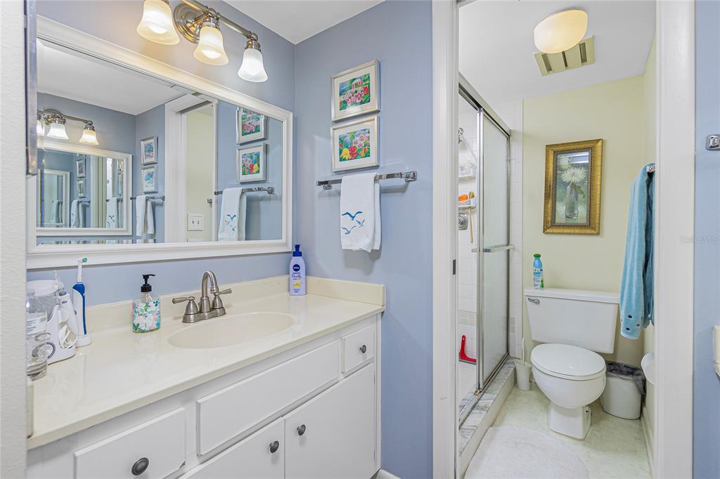 1651 Beach Road, Unit 212 Englewood, FL 34223 - Photo 22 of 50 a spacious bathroom with a sink a toilet and shower curtain