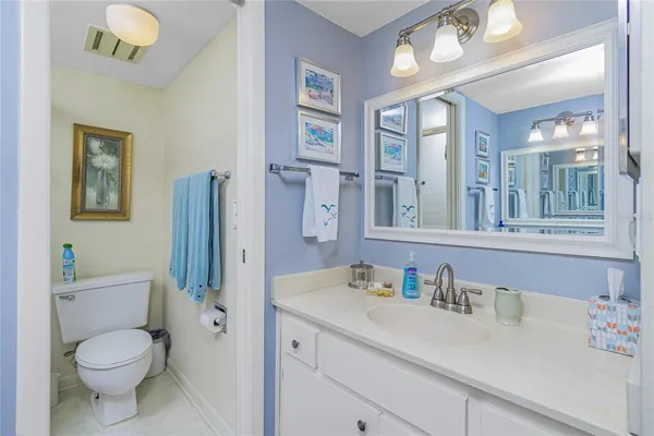 a bathroom with a toilet sink double vanity and mirror