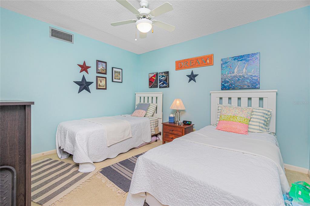 1651 Beach Road, Unit 212 Englewood, FL 34223 - Photo 26 of 50 a bedroom with 2 bed and a chandelier