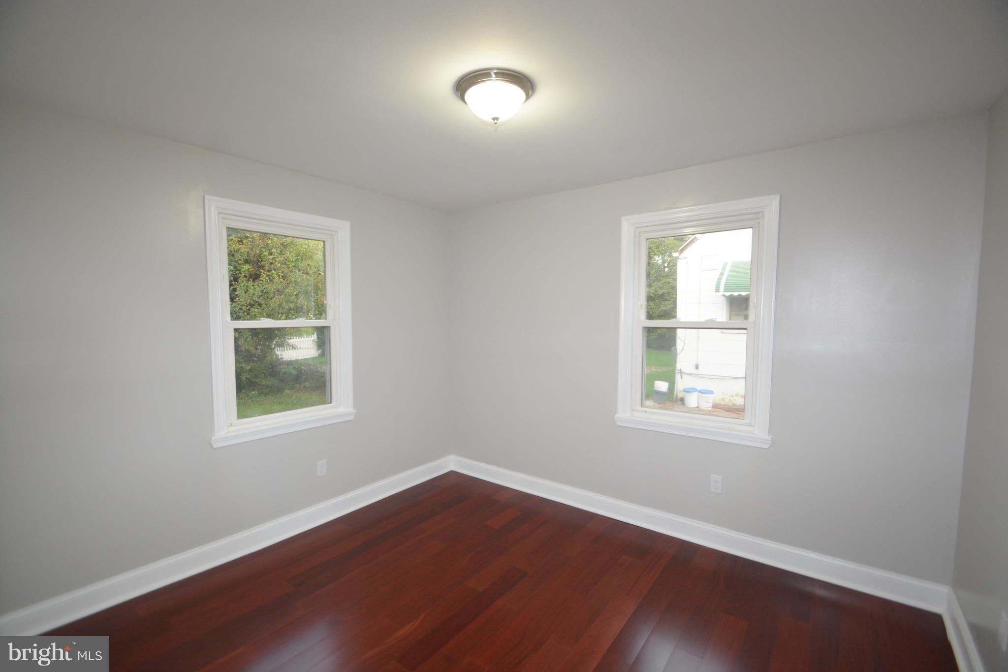 7116 Marston Road Baltimore, MD 21207 - Photo 14 of 30 an empty room with wooden floor and windows
