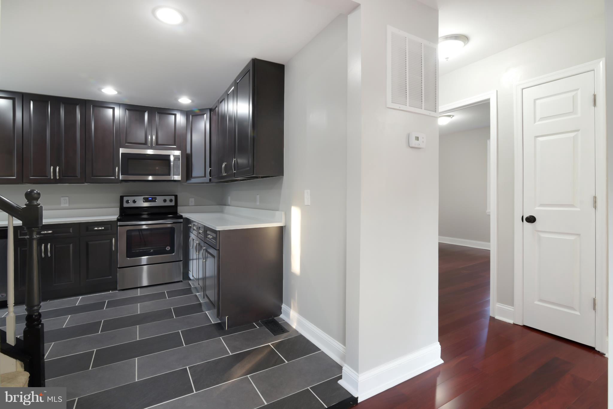 7116 Marston Road Baltimore, MD 21207 - Photo 29 of 30 a kitchen with granite countertop stainless steel appliances and wooden cabinets
