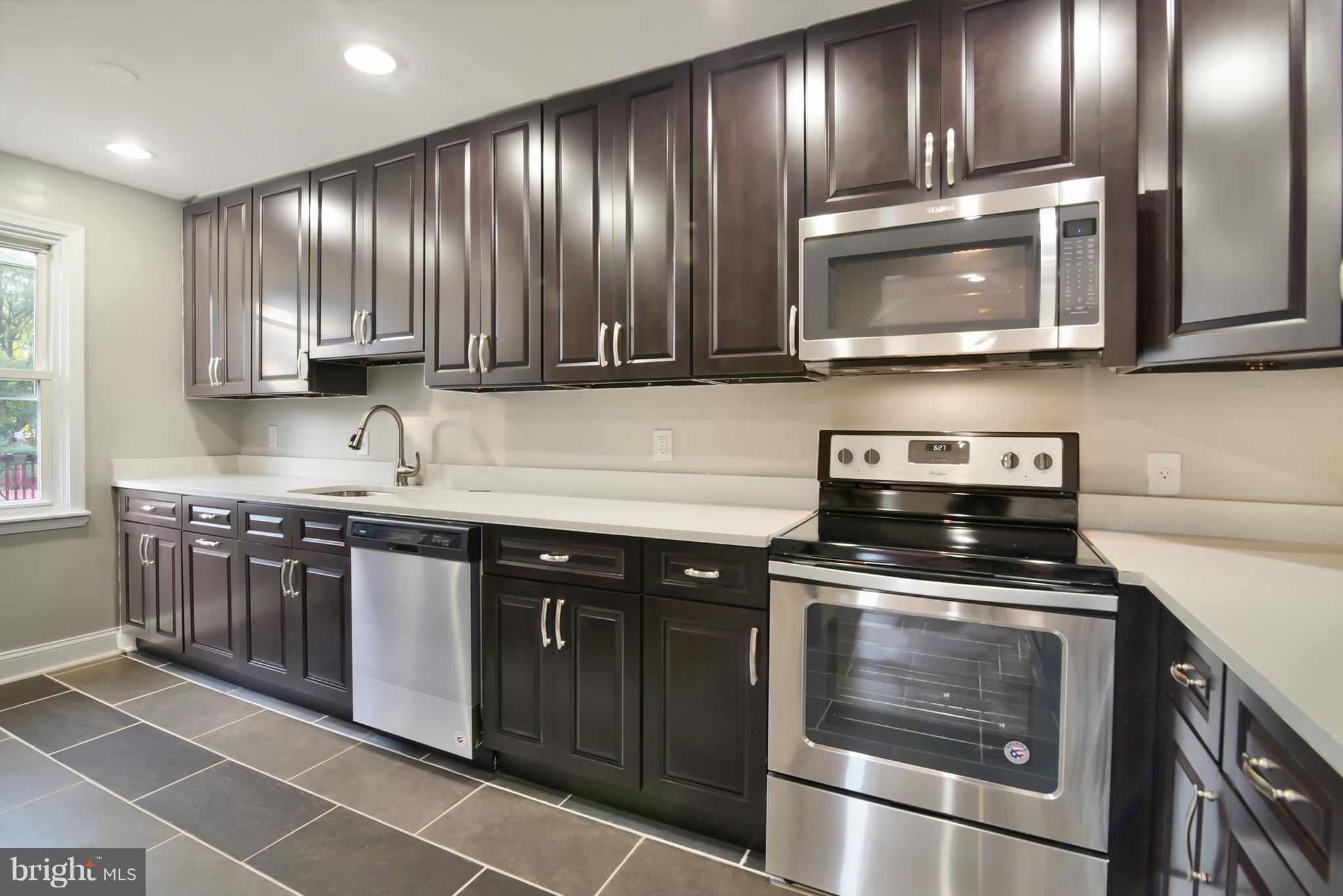 7116 Marston Road Baltimore, MD 21207 - Photo 30 of 30 a kitchen with granite countertop stainless steel appliances and wooden cabinets