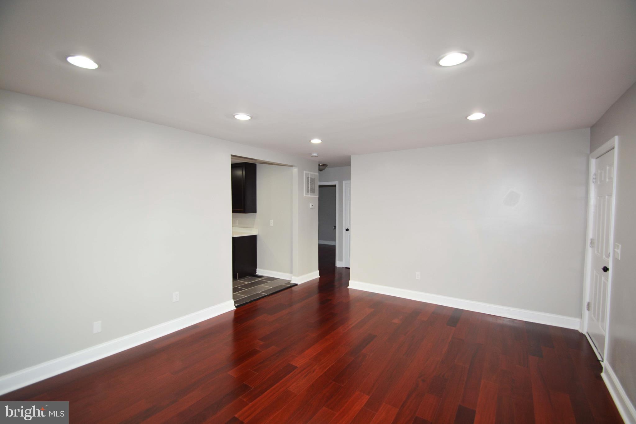 7116 Marston Road Baltimore, MD 21207 - Photo 4 of 30 an empty room with wooden floor and windows