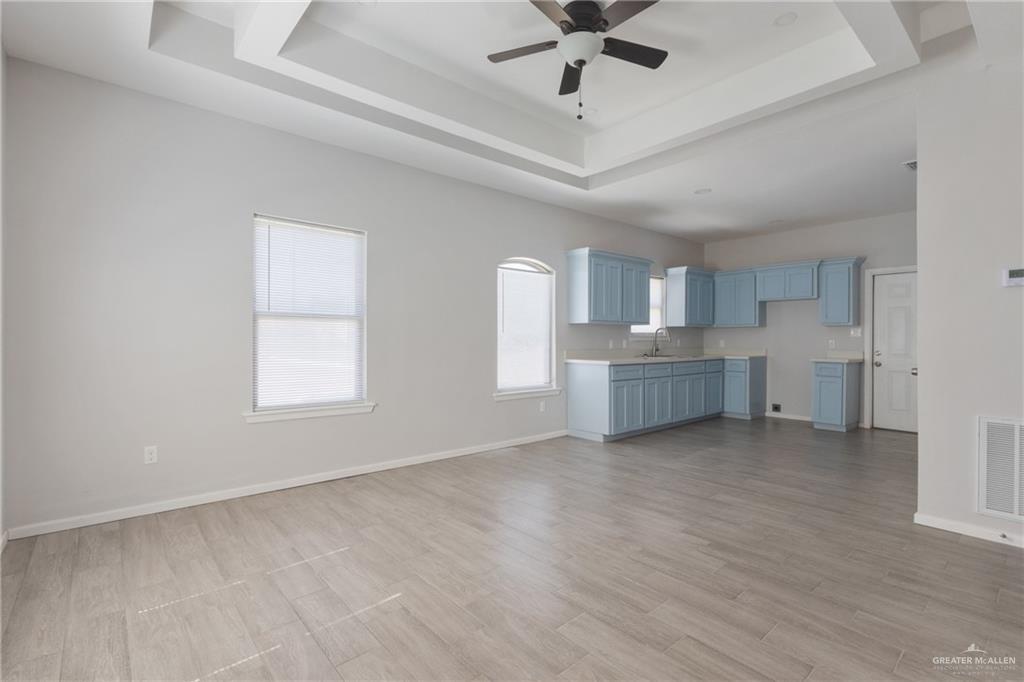 340 Eva Street, Unit 3 Edcouch, TX 78538 - Photo 3 of 12 wooden floor in an empty room with a window and a kitchen
