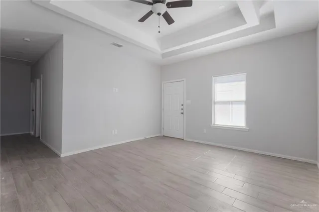 an empty room with a ceiling fan and window