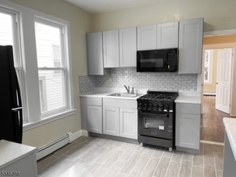 596 South 19th Street Newark, NJ 07103 - Photo 2 of 9 a kitchen with a stove and a microwave