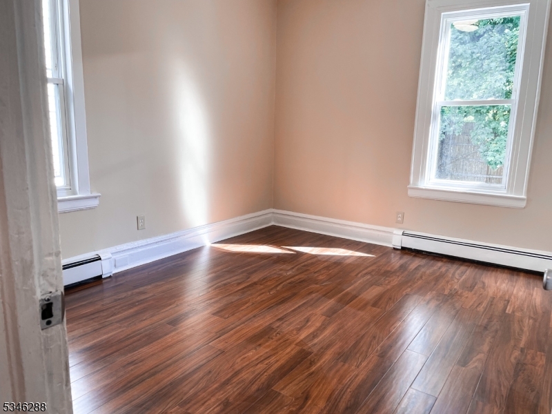 596 South 19th Street Newark, NJ 07103 - Photo 7 of 9 an empty room with wooden floor and windows