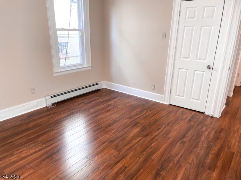 596 South 19th Street Newark, NJ 07103 - Photo 8 of 9 an empty room with wooden floor and windows