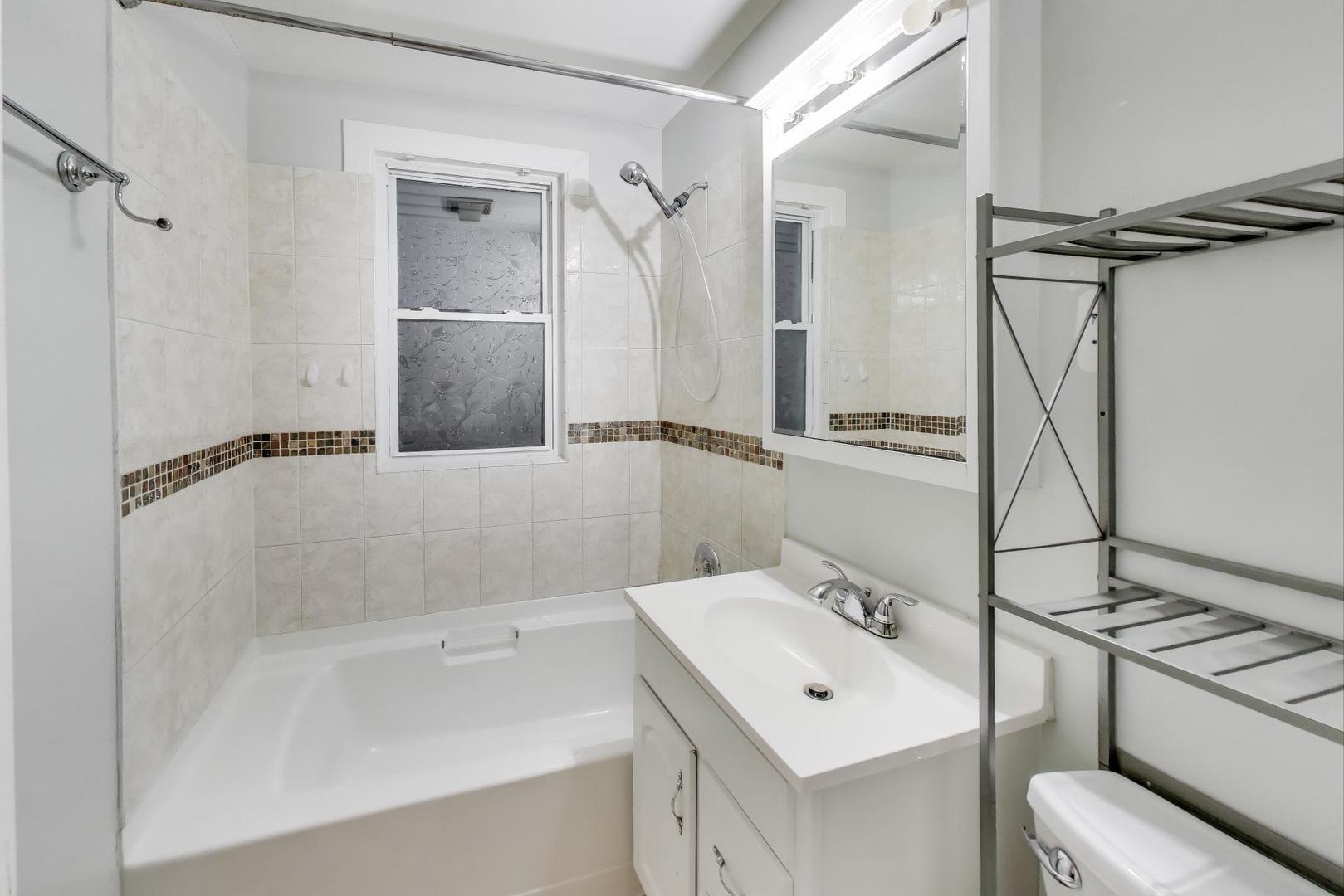 4154 North Campbell Avenue Chicago, IL 60618 - Photo 19 of 28 a bathroom with a sink a toilet and shower